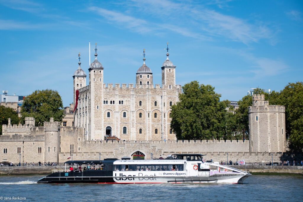 Uber boat by Thames Clippers on the river Thames with the Tower of London behind. 