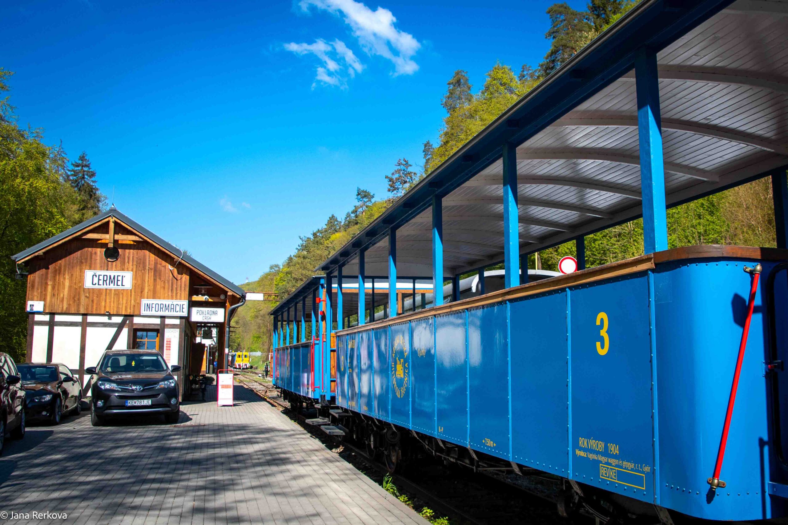 A view of the train carriage with the historic train station Cermel at the back