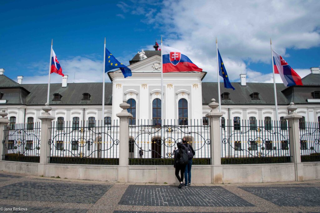 The grand, white Rococo-style front facade of the Grassalkovich Palace, the presidential residence in Bratislava, Slovakia.