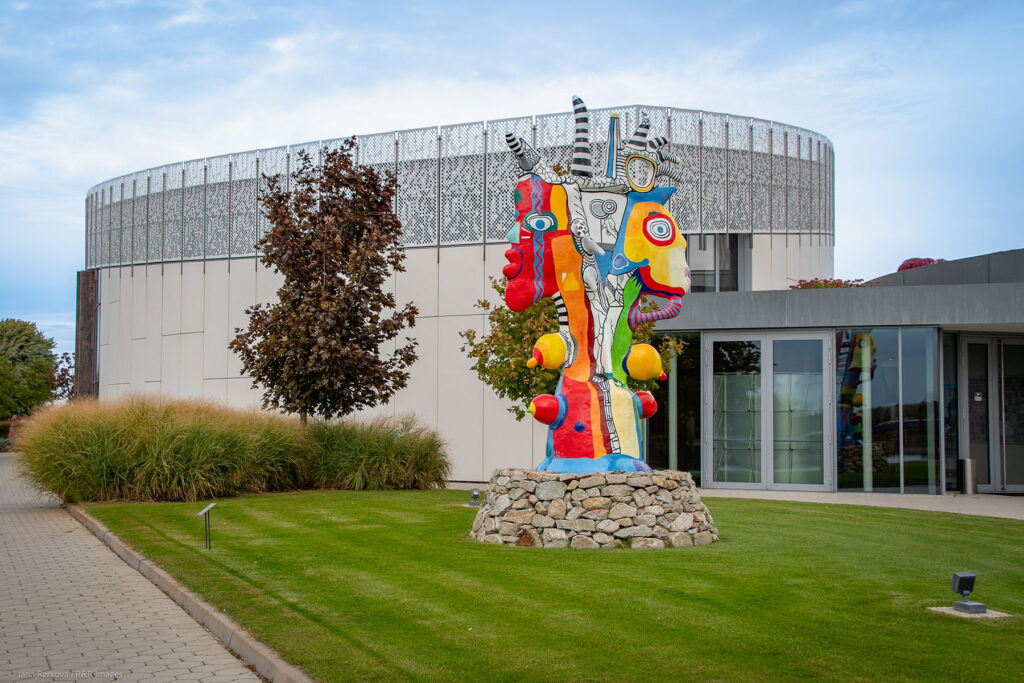 A view of the original Danubiana museum building from the sculpture park with artwork 'Smiling Faces' by Billio Nic (BE).